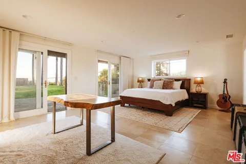 a bedroom with a bed and a large window