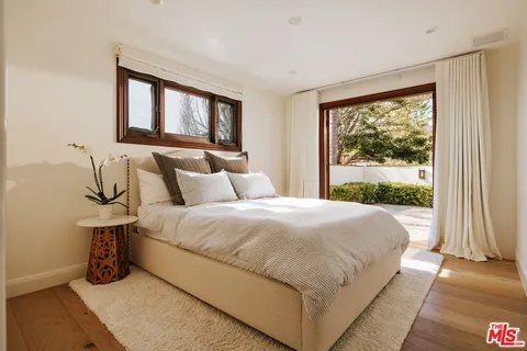 a large bed sitting in a bedroom next to a window