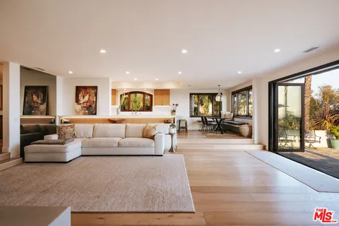 a living room with furniture and large windows