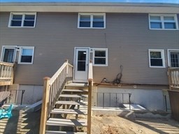 174 Pine Street, Unit 23 Holbrook, MA 02343 - Photo 25 of 25 a view of a house with wooden deck and furniture