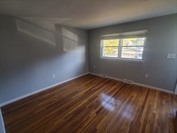 174 Pine Street, Unit 23 Holbrook, MA 02343 - Photo 9 of 25 an empty room with wooden floor and windows