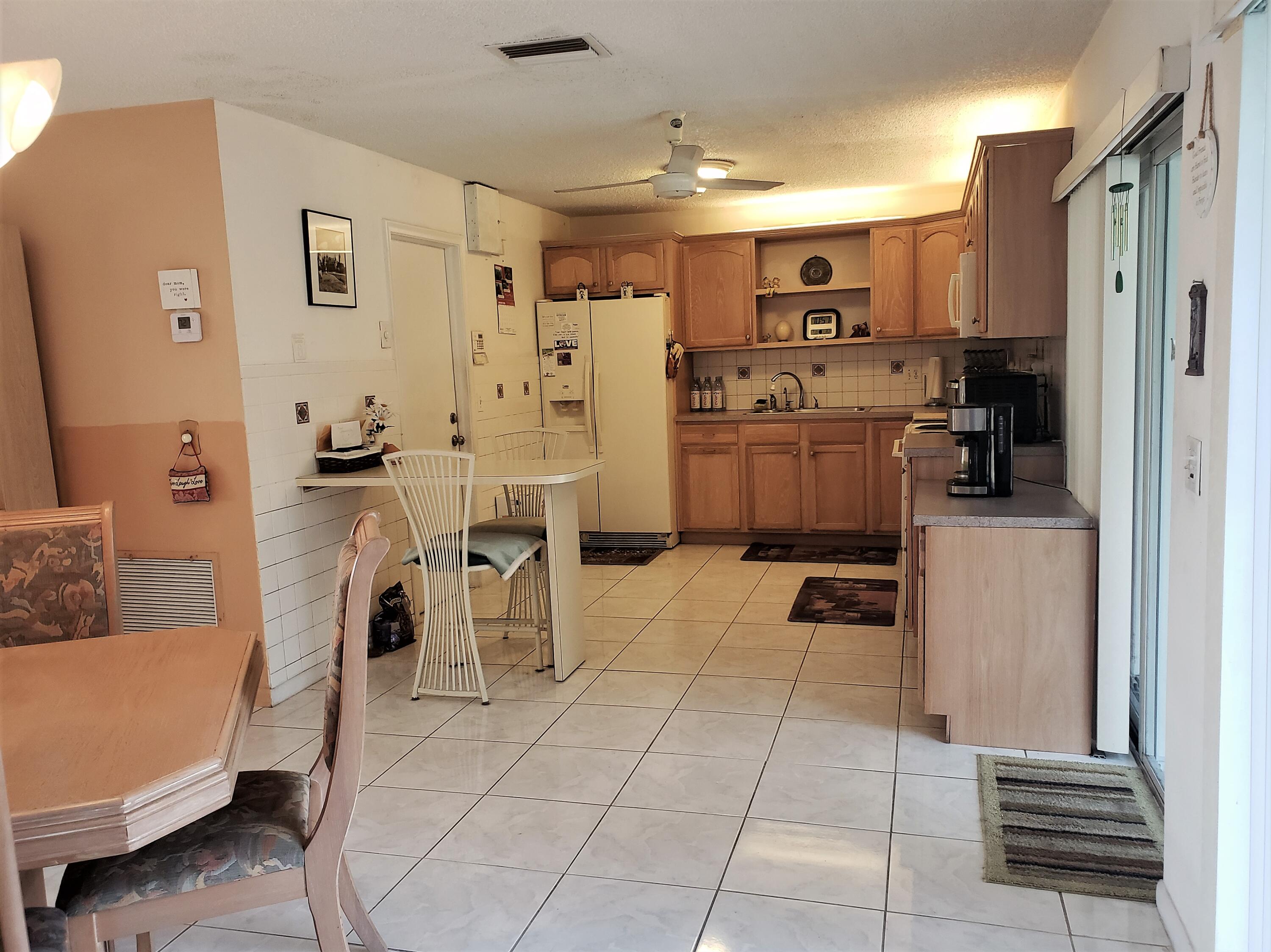 4535 Baldric Street Boca Raton, FL 33428 - Photo 7 of 19 a kitchen with stainless steel appliances a refrigerator sink and cabinets