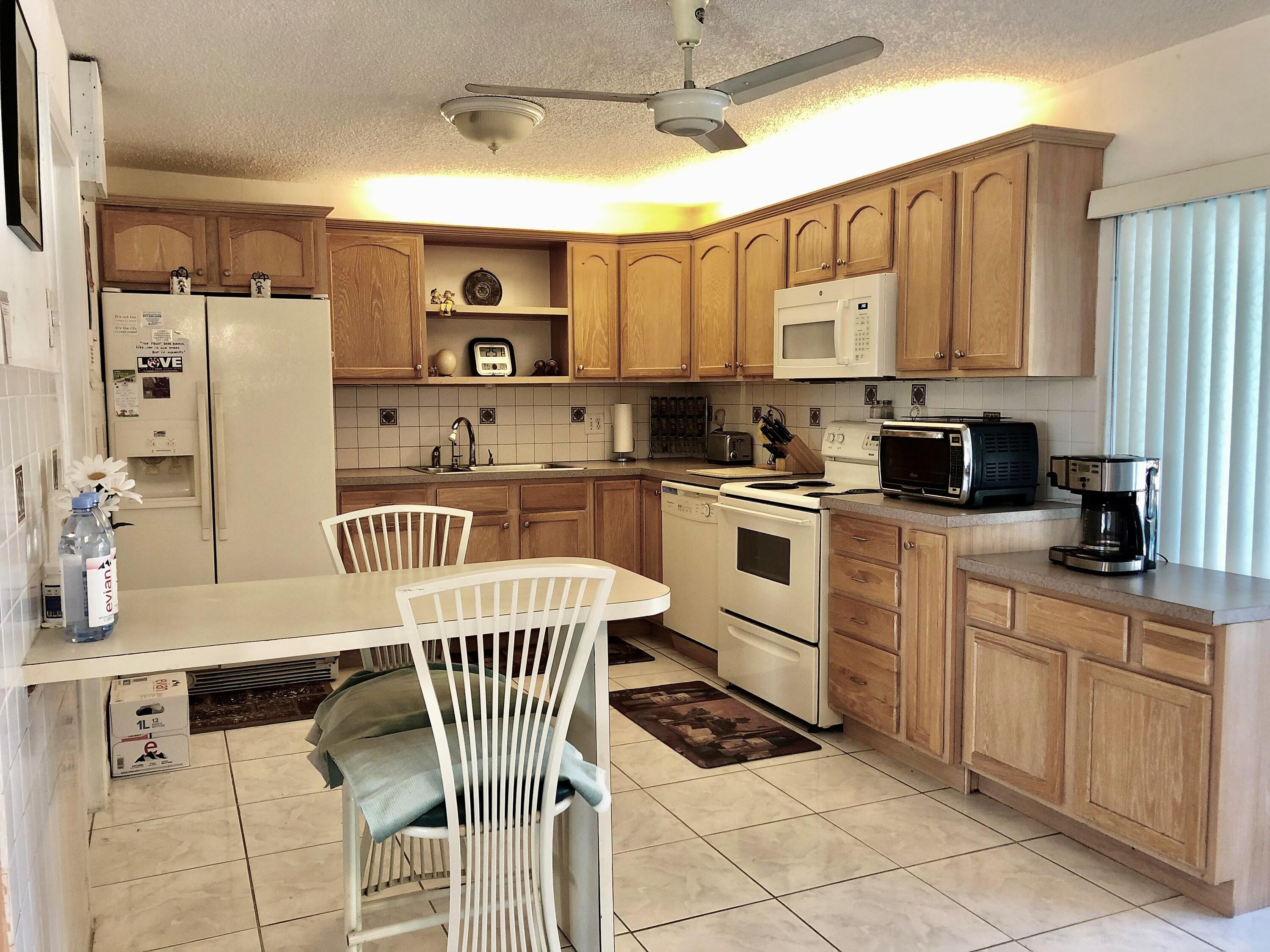 4535 Baldric Street Boca Raton, FL 33428 - Photo 8 of 19 a kitchen with a sink a counter top space cabinets stainless steel appliances and a window