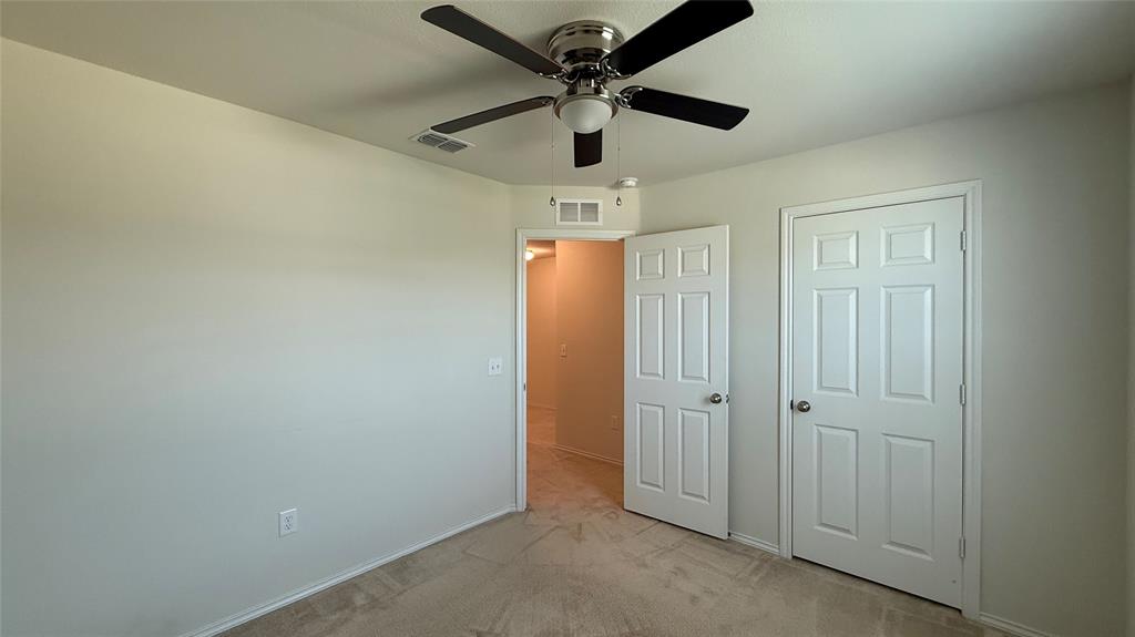 3312 Biggs Avenue Aubrey, TX 76227 - Photo 11 of 19 an empty room with ceiling fan and front door