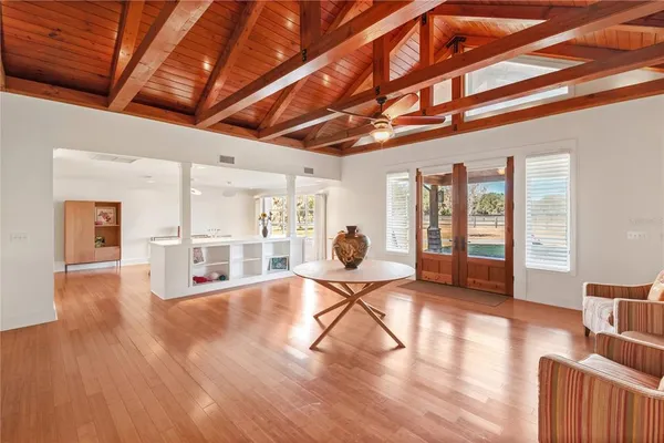 a kitchen with stainless steel appliances granite countertop a stove top oven a refrigerator a sink and a dining table with white cabinets