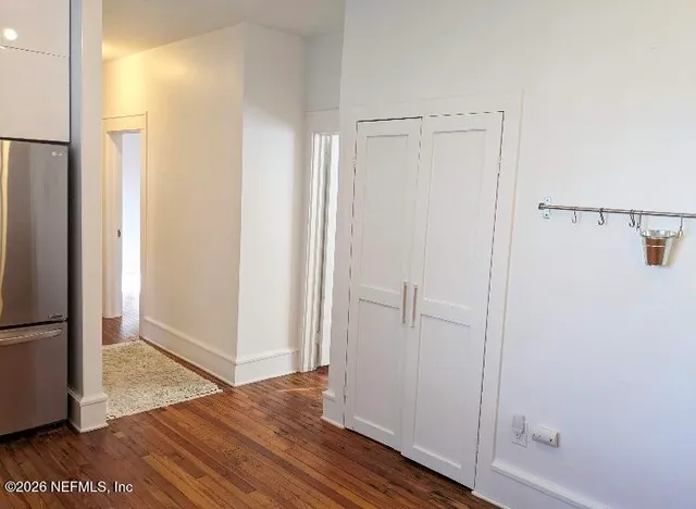a view of empty room with wooden floor