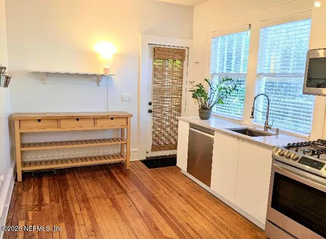 a kitchen with granite countertop a stove and a wooden floor