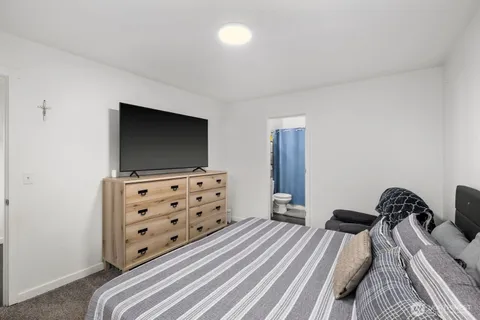 a bedroom with a bed and flat screen tv