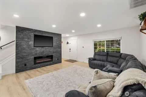 a living room with furniture a flat screen tv and a fireplace