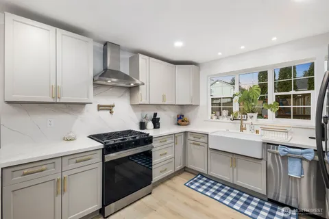a kitchen with stainless steel appliances granite countertop a sink stove and cabinets