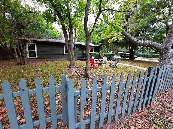 a view of house with backyard outdoor seating and trees