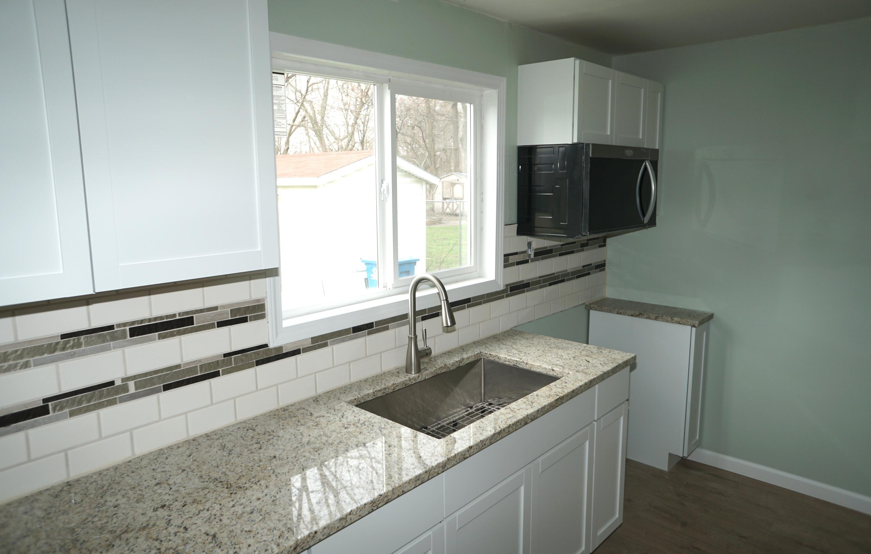 307 South East Street Knox, IN 46534 - Photo 8 of 15 a kitchen with stainless steel appliances granite countertop a sink stove and microwave