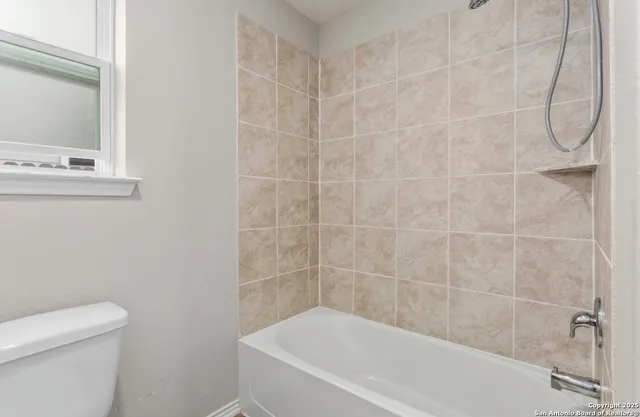 a white bath tub sitting next to a white toilet and a shower