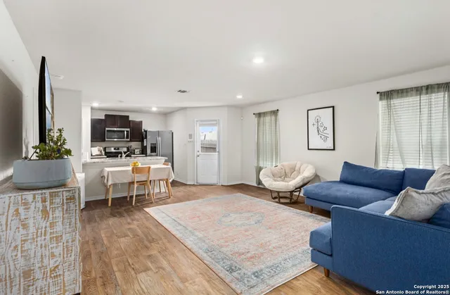 a living room with furniture wooden floor and a flat screen tv