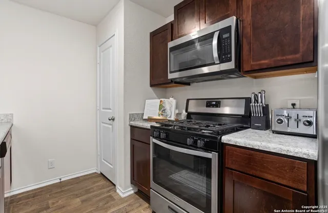 a kitchen with stainless steel appliances wooden cabinets and a stove top oven