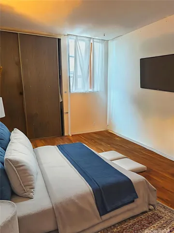 a bedroom with a bed and flat screen tv