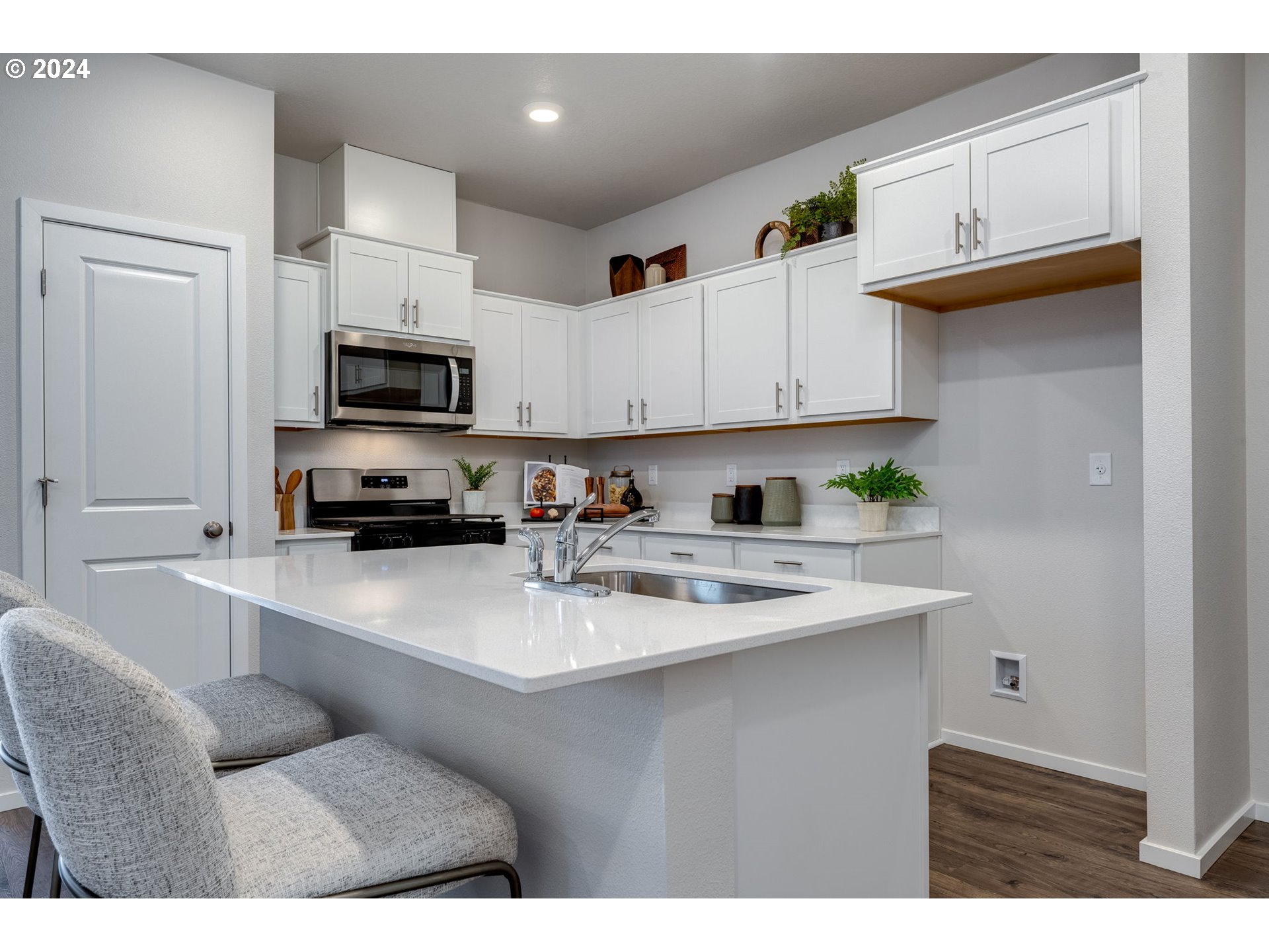 2760 U Street Springfield, OR 97477 - Photo 19 of 48 a kitchen with kitchen island a sink dishwasher a stove a microwave oven and a cabinets with wooden floor