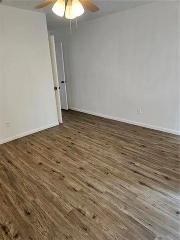 a view of a room with wooden floor and a ceiling fan