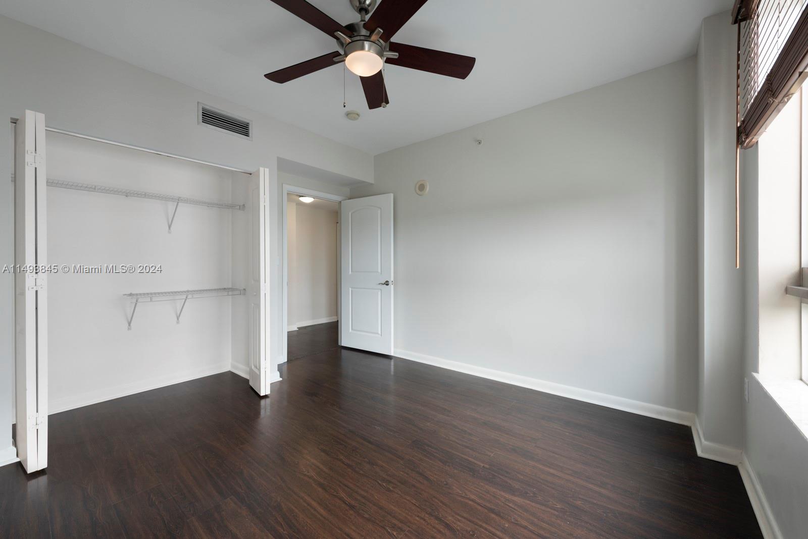 7355 Southwest 89th Street, Unit 510N Miami, FL 33156 - Photo 23 of 52 a view of an empty room with wooden floor and a window