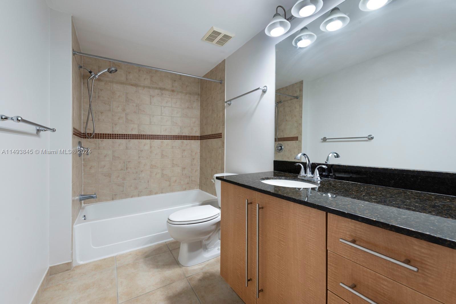 7355 Southwest 89th Street, Unit 510N Miami, FL 33156 - Photo 24 of 52 a bathroom with a granite countertop sink a toilet and shower