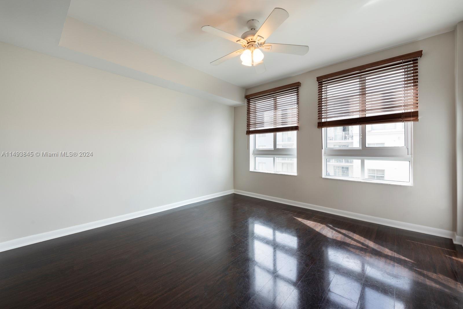 7355 Southwest 89th Street, Unit 510N Miami, FL 33156 - Photo 27 of 52 an empty room with wooden floor and windows