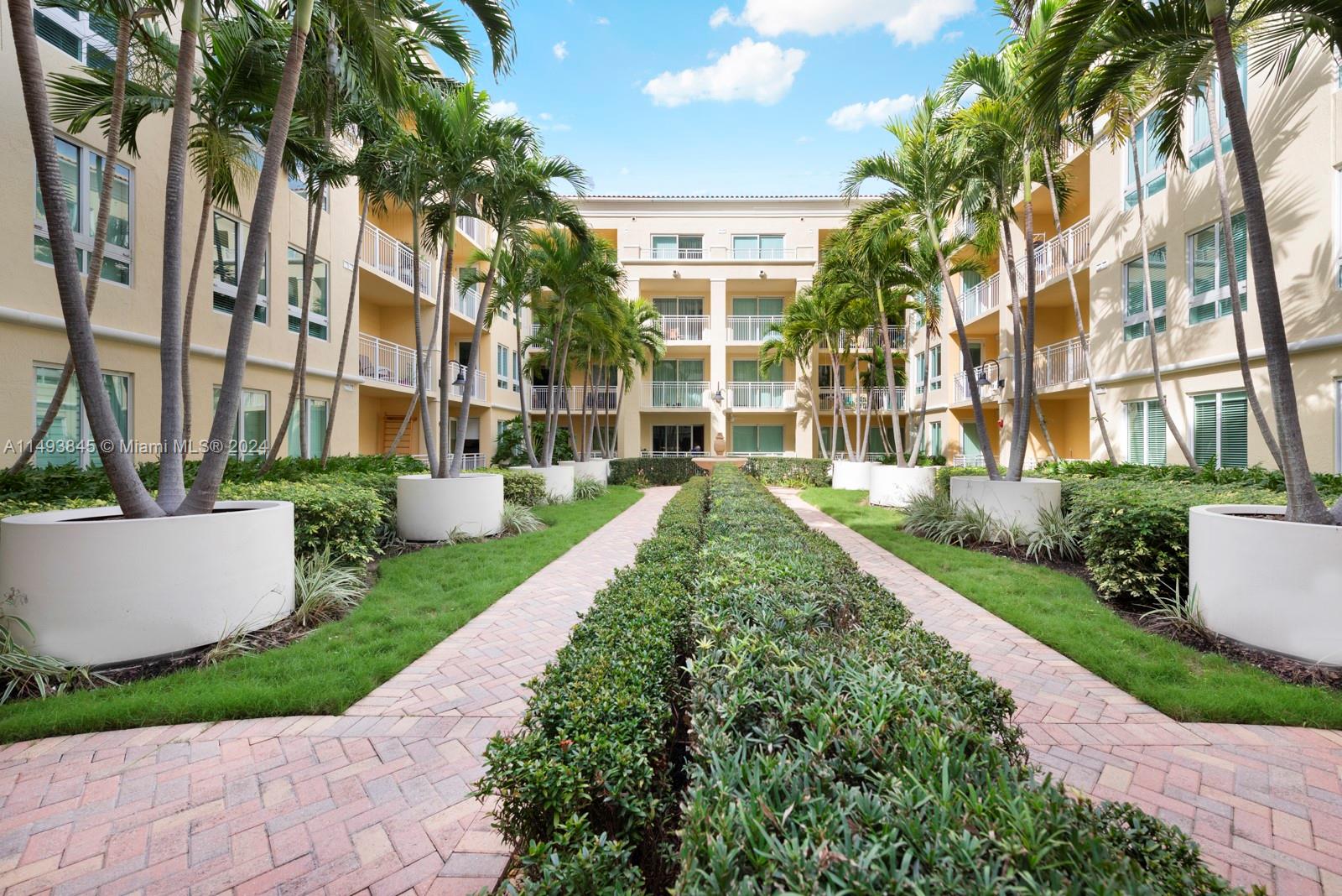 7355 Southwest 89th Street, Unit 510N Miami, FL 33156 - Photo 34 of 52 a view of a building with a yard and potted plants