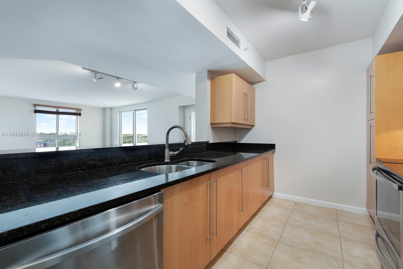7355 Southwest 89th Street, Unit 510N Miami, FL 33156 - Photo 10 of 52 a kitchen with granite countertop a sink and a stove