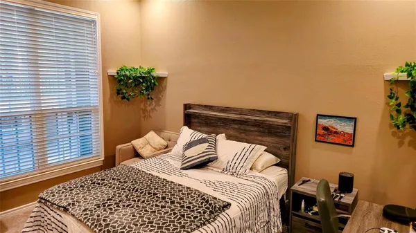 a bedroom with a bed and a potted plant