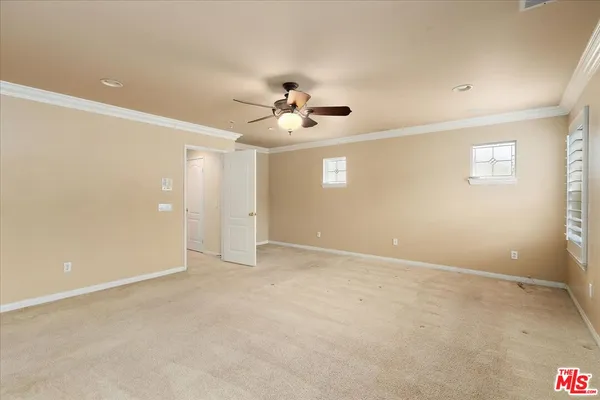 an empty room with ceiling fan and window