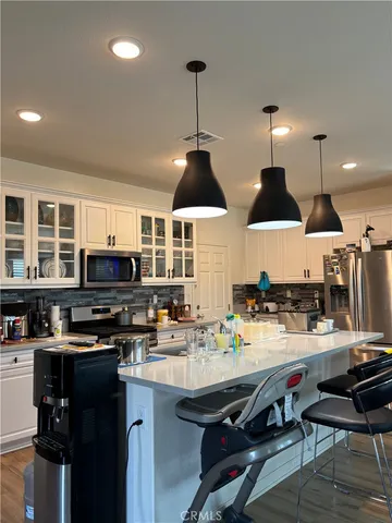 a kitchen with stainless steel appliances a stove a sink a dining table and chairs
