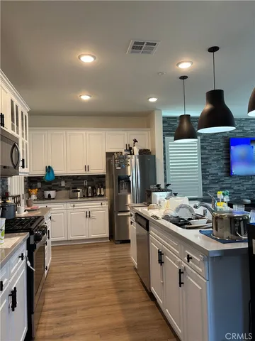 a kitchen with stainless steel appliances granite countertop a stove sink and refrigerator