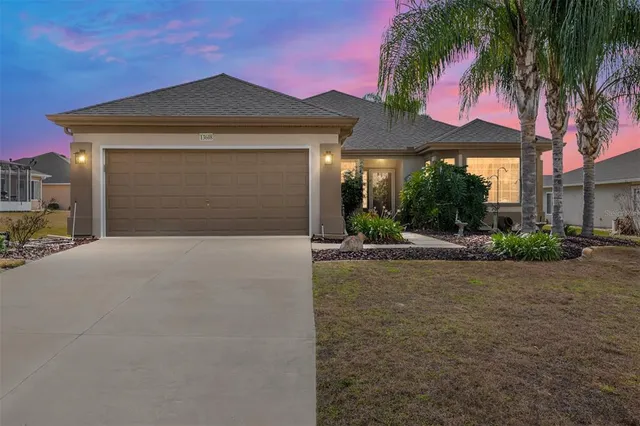 a front view of a house with yard garage and outdoor seating