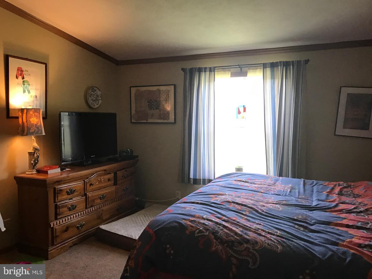 25795 Garey Road Denton, MD 21629 - Photo 13 of 22 a bedroom with a bed and a flat screen tv