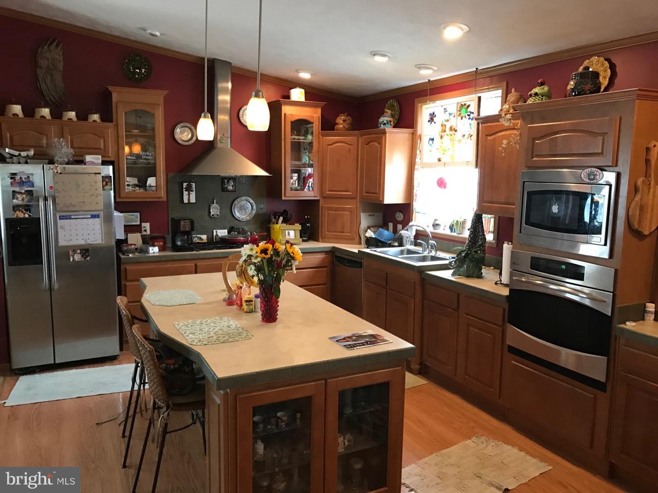 25795 Garey Road Denton, MD 21629 - Photo 5 of 22 a kitchen with a kitchen island wooden cabinets and refrigerator