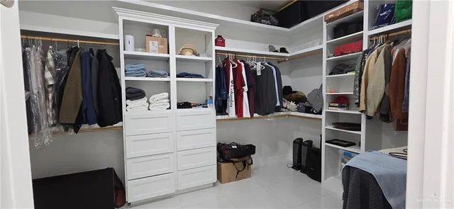a view of walk in closet with clothes and shoes