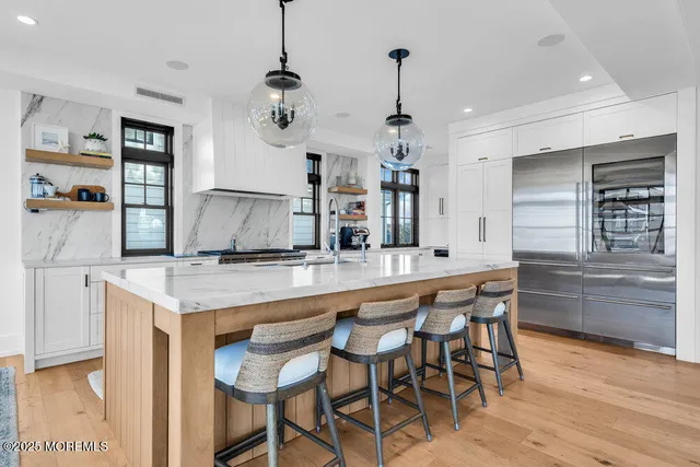 a kitchen with stainless steel appliances granite countertop a sink and a refrigerator
