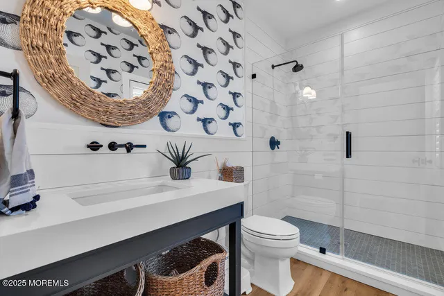 a bathroom with a sink a toilet and shower