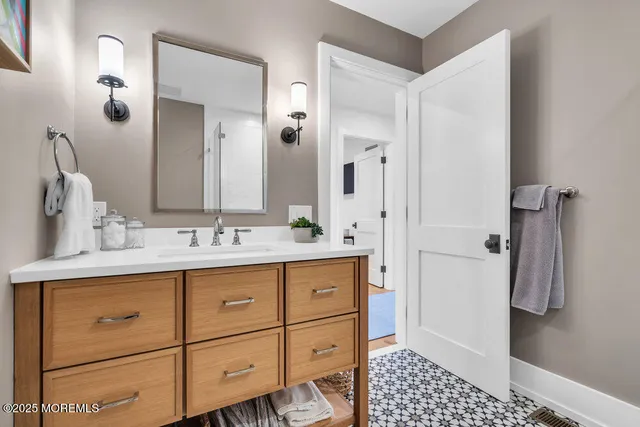 a bathroom with a double vanity sink a mirror a toilet and a shower