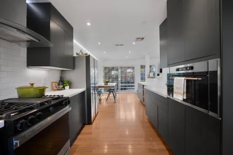 a kitchen with stainless steel appliances a sink a stove top oven a counter space and cabinets