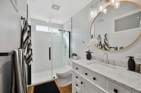 a bathroom with a double vanity sink toilet and shower
