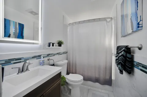 a bathroom with a sink toilet and shower