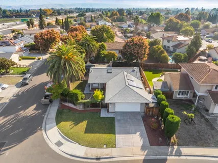 an aerial view of residential houses with outdoor space and parking