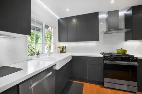 a kitchen with stainless steel appliances a sink stove and cabinets