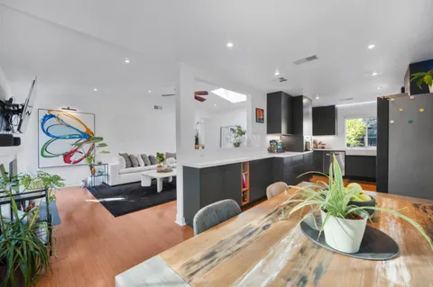 a living room with furniture kitchen and a potted plant