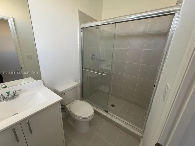 a bathroom with a shower a toilet and sink