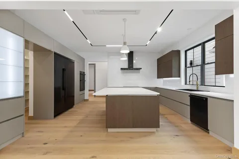 a large kitchen with stainless steel appliances granite countertop a lot of cabinets and wooden floor