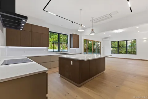 a large kitchen with kitchen island a large counter top space appliances and windows
