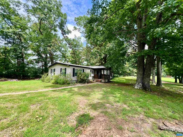 a view of a house with a yard and tree s