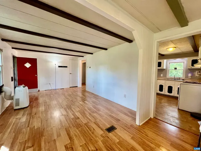 a very nice looking room with wooden floor and furniture