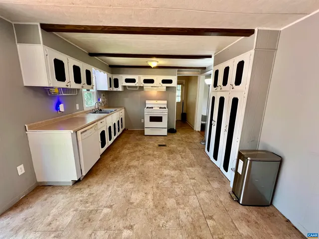 a view of a kitchen with fridge and wooden floor
